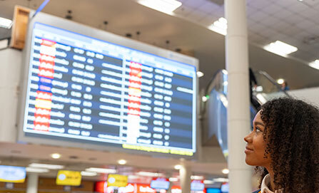 Female traveler looks at departures in an airport.