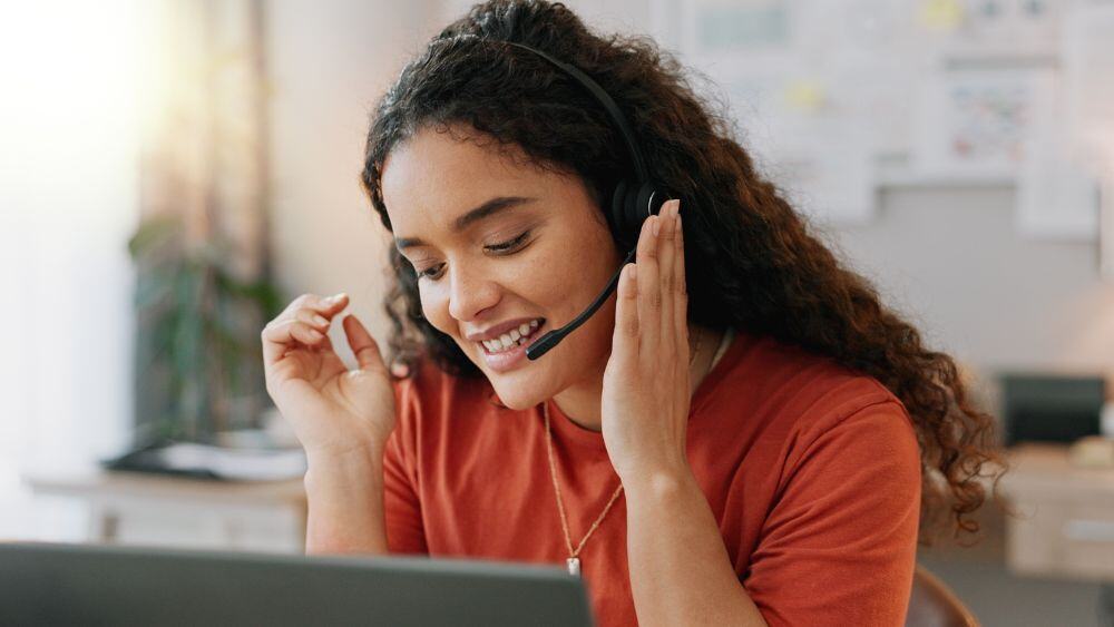 Work at home customer service agent talks enthusiastically via headset to a customer