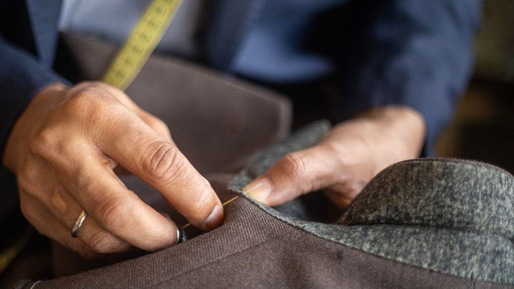 Tailor adjusts seam on luxury suitcoat