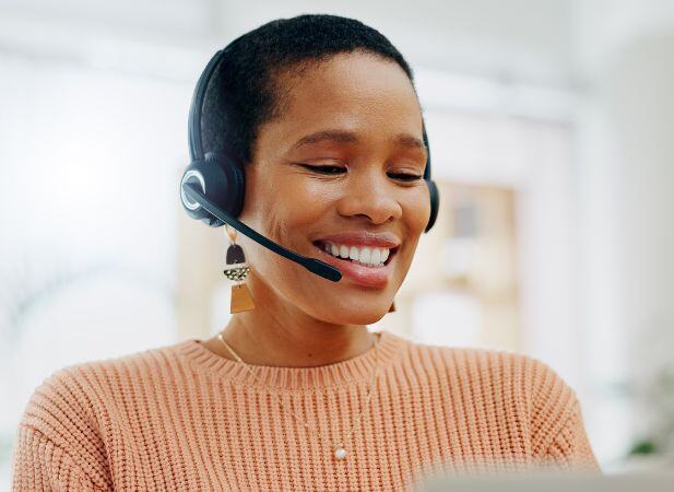 Smiling happy customer service representative sits at home