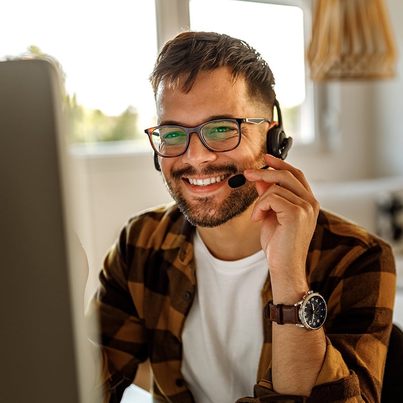 customer service agent holding headset while working in computer