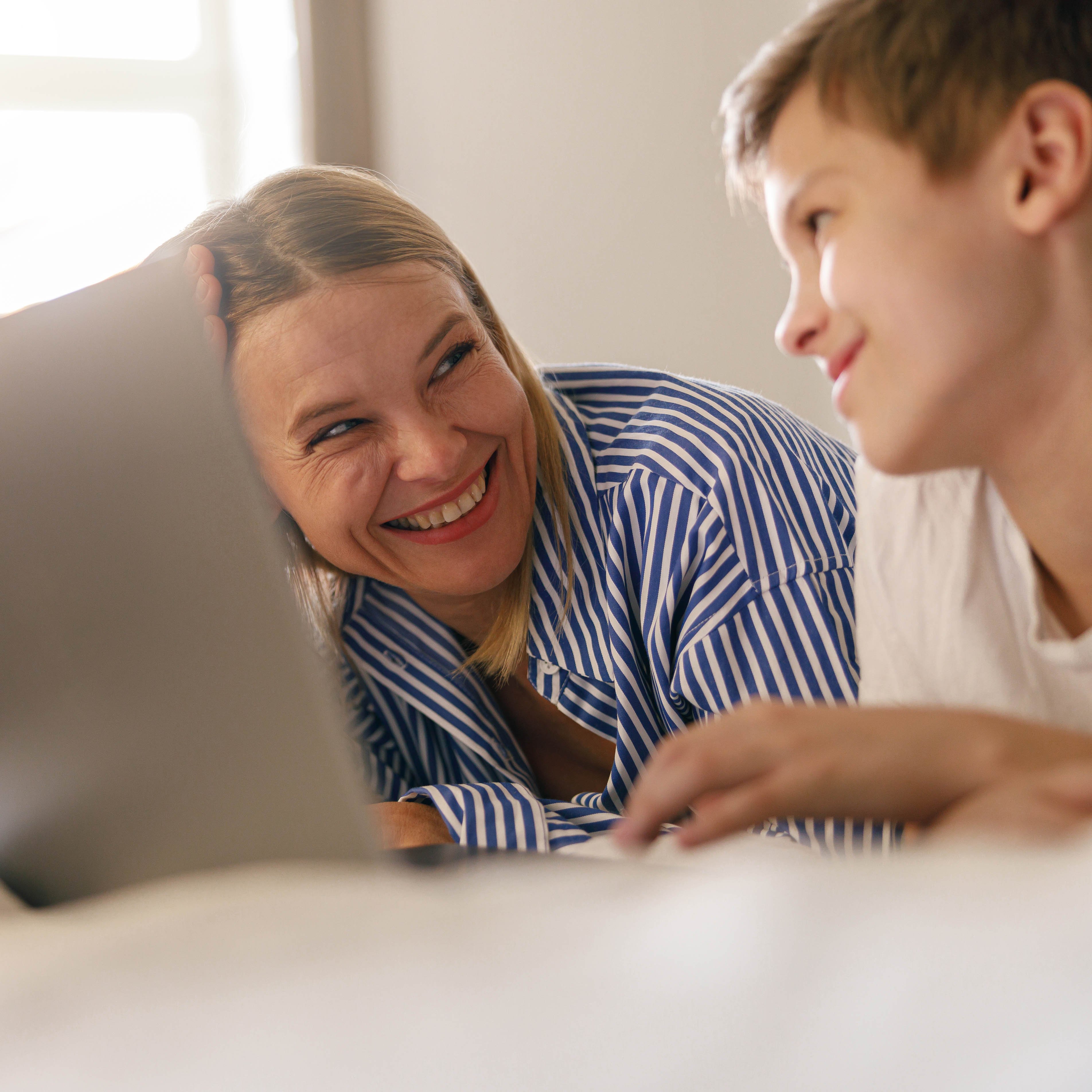 smiling-mom-with-small-son-lying-on-bed-and-lookin-2023-11-27-05-01-03-utc copy-1